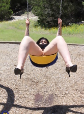 Funny mature woman enjoys riding on a swing with nude vagina