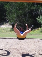 Funny mature woman enjoys riding on a swing with nude vagina