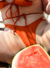 Cougar with big tits provocatively eats juicy watermelon under the sun