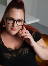 Glasses-wearing BBW posing and squeezing her boobies too