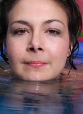Older woman with a young face is getting wet in the pool
