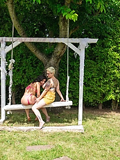 Lesbian couple tease and play on garden swing