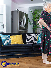 ature granny solo tease on couch with bush, sagging tits, pussy out, spread pose