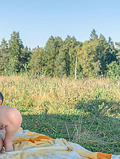 Outdoor nude blonde babe flaunting natural tits and bare pussy in spread pose