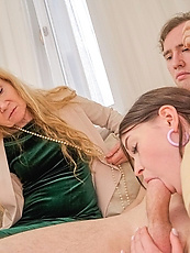 Mature MILF and young babe strip naked for raw threesome blowjob on couch